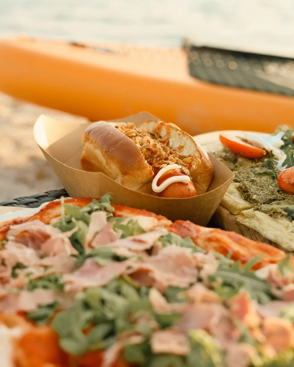 Close-up of a hot dog and flatbread at Moana Beach Bar with the sea in the background